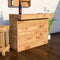 Wooden bar cabinet with a bottle and glasses on top in a home setting